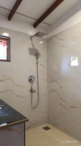 a bathroom with a shower in a wall at White Umbrella - Homestay in Beruwala