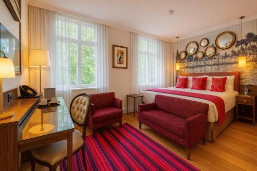a hotel room with a bed and a desk and chairs at Hotel Indigo London Hyde Park Paddington by IHG in London