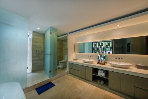 a large bathroom with two sinks and a shower at The Muse Luxury Eco-Living in Munggu