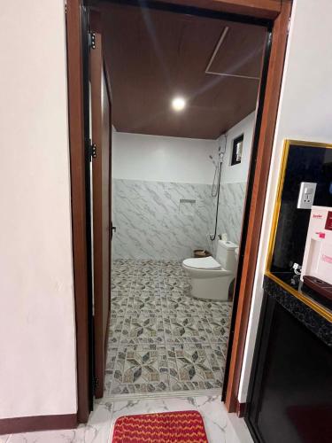 a bathroom with a toilet and a door open at JoRich Guest House in Siquijor