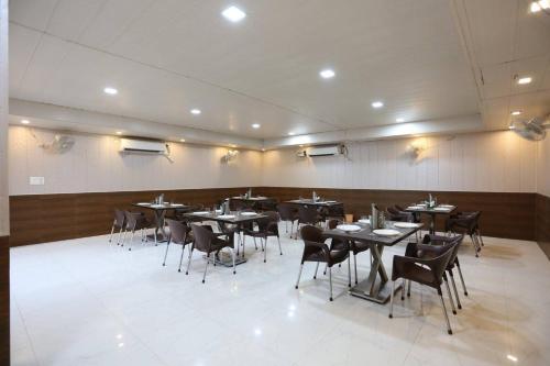 a restaurant with tables and chairs in a room at Hotel Ganges Park in Haridwār
