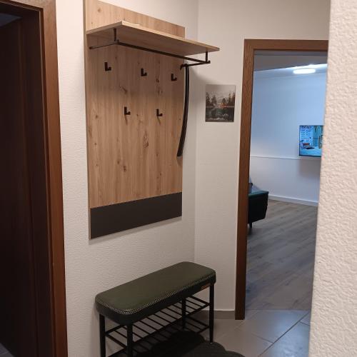 a hallway with a stool and a wooden cabinet at Ferienwohnung Grünes Leben in Simmerath