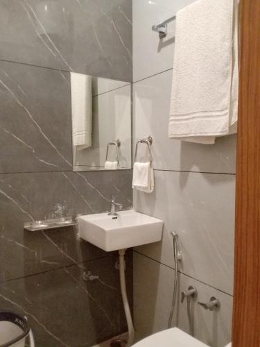 a bathroom with a sink and a toilet and a mirror at Hotel Pushkar Town in Pushkar