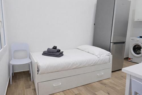 a small white kitchen with a bed and a refrigerator at Comfortable 1-Bedroom Central Menton in Menton