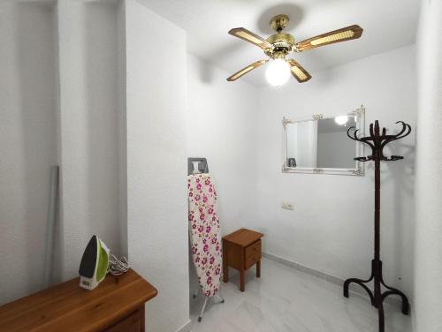 a white room with a ceiling fan and a dresser at 009 Bungalow Torrelamata in La Mata