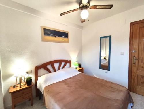 a bedroom with a bed and a ceiling fan at 009 Bungalow Torrelamata in La Mata