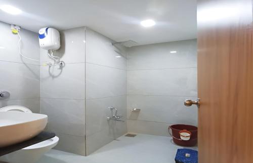 a bathroom with a shower and a toilet and a sink at Hotel shree Tapovan in Ahmedabad