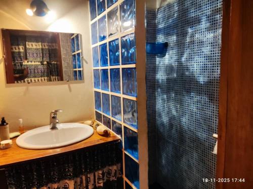 ein Badezimmer mit Waschbecken und Glasdusche in der Unterkunft Baobab Beach Villa in Abémé