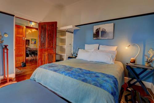 a bedroom with a large bed with a blue wall at Harbour House Mossel Bay - near sea & activities in Mossel Bay