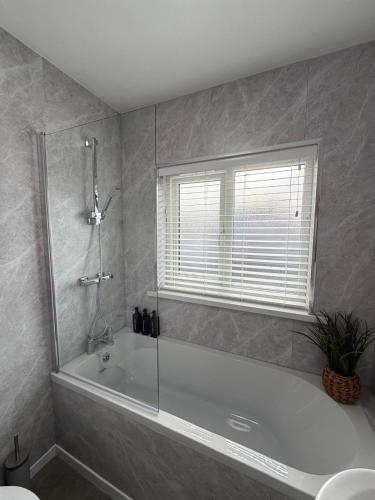 a bathroom with a bath tub and a window at Parkfield House in Smethwick