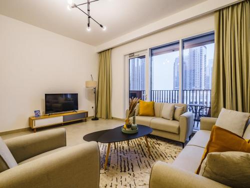 a living room with two couches and a tv at Incredible Waterfront Apt with Panoramic Views in Dubai