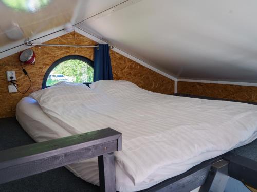 a bed in a tent with a window at Kelluva Jokimaja in Turenki