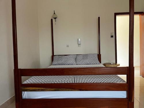 a bed with a wooden frame in a room at A quiet corner in Cotonou in Cotonou