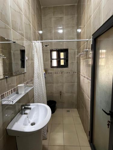 a bathroom with a sink and a shower at A quiet corner in Cotonou in Cotonou