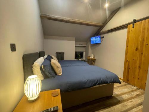 a bedroom with a bed and a table and a tv at Quarrymen's Arms in Nant-y-bwch