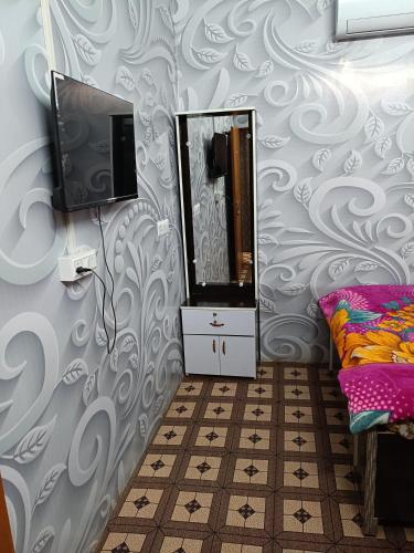 a room with a tv and a mirror on a wall at Oyo Royal Hotel & Janmasha in Rewa
