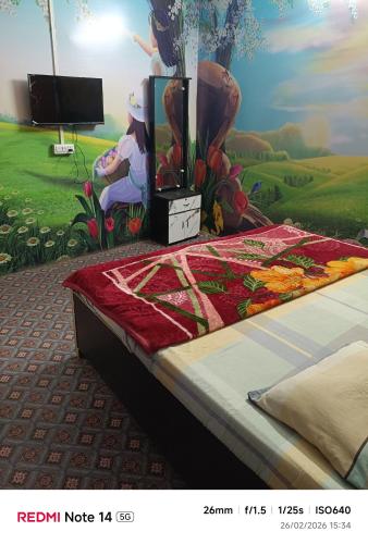 a bedroom with a bed with a painting on the wall at Oyo Royal Hotel & Janmasha in Rewa
