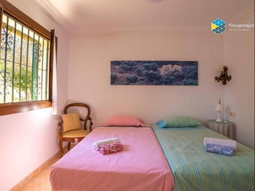 two twin beds in a room with a window at Can Moreu in Caimari