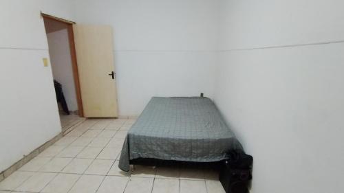 a small bed in a room with a tiled floor at Chacrinha in Campinas