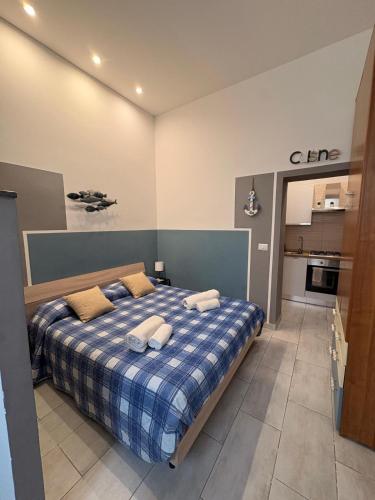 a bedroom with a bed with a blue plaid blanket at CASETTA DEL SARACENO in Roccalumera