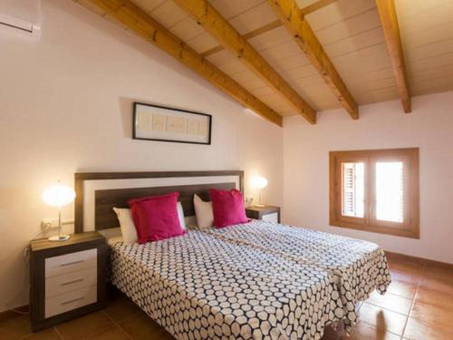 a bedroom with a large bed with pink pillows at Ca'n Climent in Llucmajor