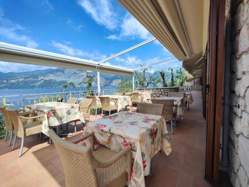 a restaurant with tables and chairs with a view of the ocean at Residence Casa Maria in Assenza di Brenzone