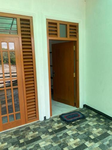 an empty room with doors and a room with a mat at Chandani Hostel in Galle