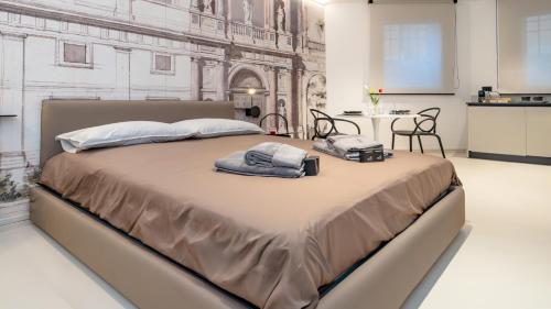 a bedroom with a large bed with two towels on it at DOMUS 1435 - Iconic Suites in Centro in Mantova