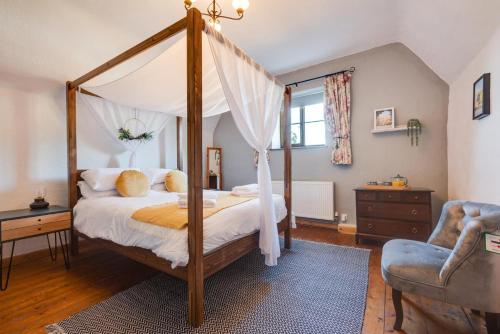 a bedroom with a canopy bed and a chair at 2 Bed in Heacham oc-2365 in Heacham