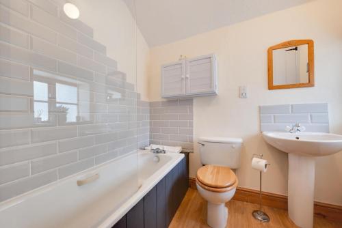 a bathroom with a toilet and a sink and a tub at 2 Bed in Heacham oc-2365 in Heacham