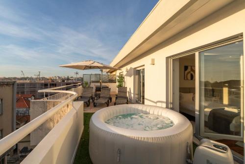a hot tub on the balcony of a house at Bright Beachside Flat with Terrace by HostWise in Matosinhos