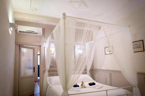 フィレンツェにあるOltrarno Florence Apartmentのベッドルーム(白いカーテン付きの天蓋付きベッド1台付)