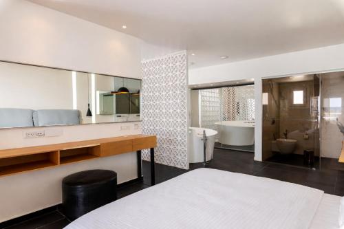 ein Badezimmer mit Waschbecken, Toilette und Badewanne in der Unterkunft Mykonos Kosmoplaz Beach Resort Hotel in Platis Gialos