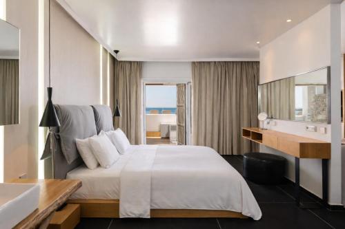 ein Hotelzimmer mit Bett und Badezimmer in der Unterkunft Mykonos Kosmoplaz Beach Resort Hotel in Platis Gialos