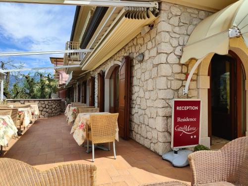 a restaurant with chairs and a sign on the side of a building at Residence Casa Maria in Assenza di Brenzone