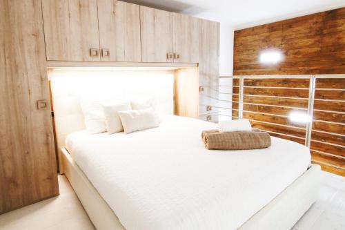 1 dormitorio con 1 cama blanca grande y armarios de madera en Alessia's Flat - Portello, en Milán