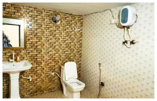 a bathroom with a white toilet and a sink at Hotel Indra Palace Jaunpur in Jaunpur