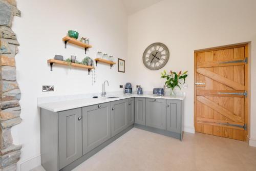 a kitchen with a sink and a clock on the wall at 3 Bed in Trawsfynydd oc-wag718 in Trawsfynydd