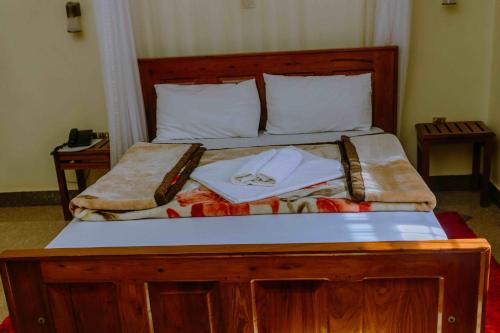 a bedroom with a wooden bed with a wooden frame at Dream Kilimanjaro Complex Hotel in Msaranga
