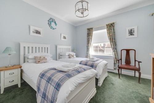 a bedroom with two beds and a chair at 3 Bed in Holt oc-2280 in Holt