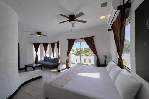 a bedroom with a white bed and a ceiling fan at Hotel Villa Capricho in Ciudad Madero