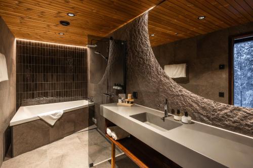 a bathroom with a sink and a bath tub at Gáldu Hotel & Spa in Saariselka