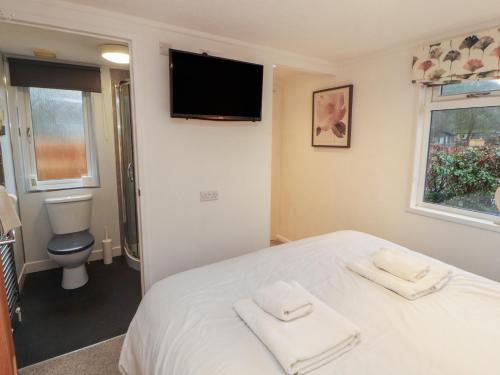 a bedroom with a bed with two towels on it at Dovedale Lodge in Windermere