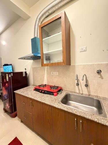 a kitchen counter with a sink and a refrigerator at Moonstone Royal Resort in Jāmb