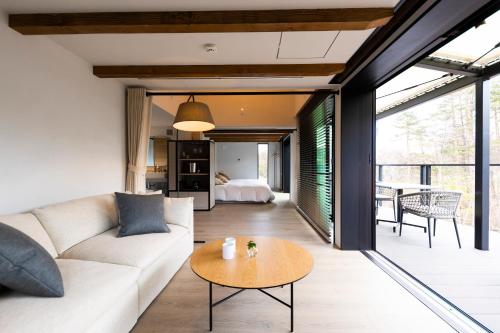 a living room with a couch and a table at The SENSE FUJI in Narusawa