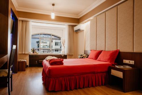 a bedroom with a red bed and a window at Tac Premier Hotel & Spa in Alanya