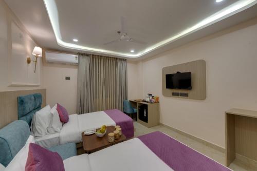 a hotel room with a bed and a tv at Click Collection Ayodhya in Ayodhya