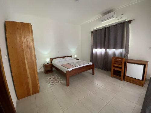 a bedroom with a bed and a television in it at Residencial Aeroporto in São Tomé