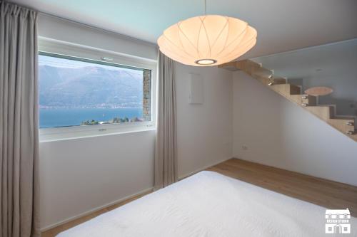 a bedroom with a large window with a view at APPARTAMENTO BELAGO by Design Studio in Bellano