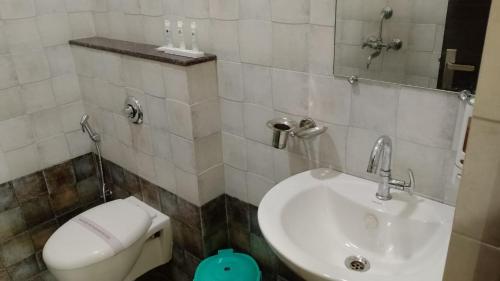 a bathroom with a toilet and a sink at Hotel Govindam Elite in Juhi Bari